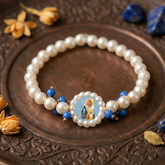 Devotional Pearl Bead Bracelet with Spiritual Centerpiece & Blue Accent Charms