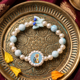 Sacred Grace: Sky Blue Marbled Bead & Pearl Rakhi Bracelet with Divine Deity Centerpiece