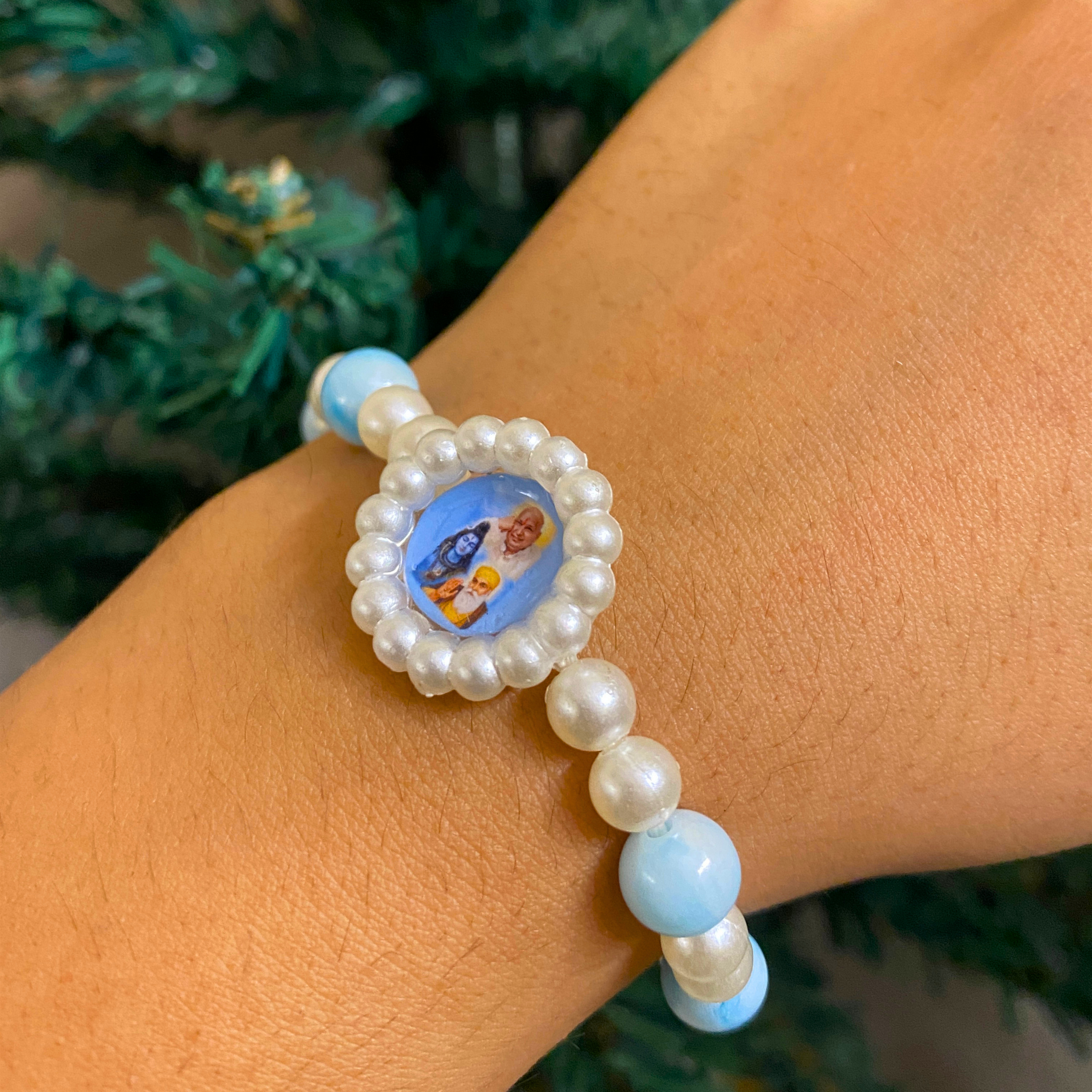 Sacred Grace: Sky Blue Marbled Bead & Pearl Rakhi Bracelet with Divine Deity Centerpiece